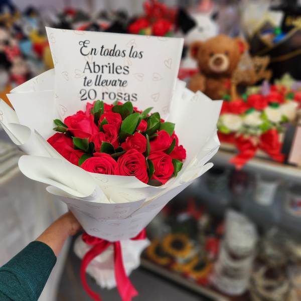 Bouquet of red roses wrapped in white paper with a ribbon