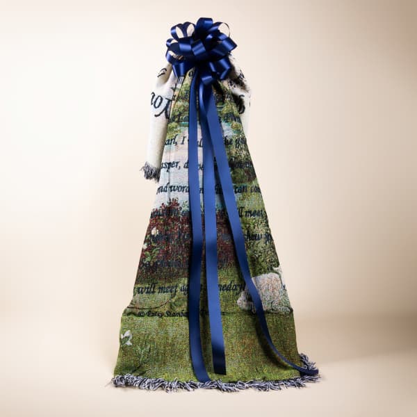 A decorative woven throw with a large blue ribbon bow.