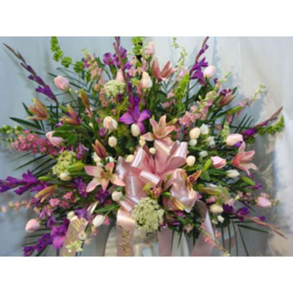 Large pink and purple floral spray with ribbon accents