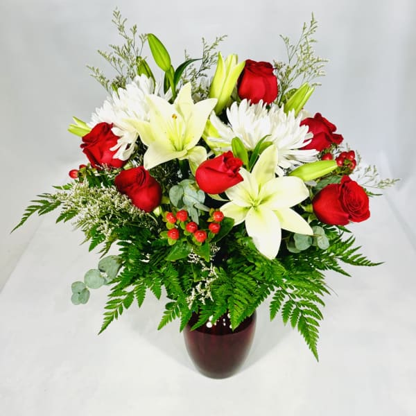 Bouquet of red roses and white lilies in a dark vase