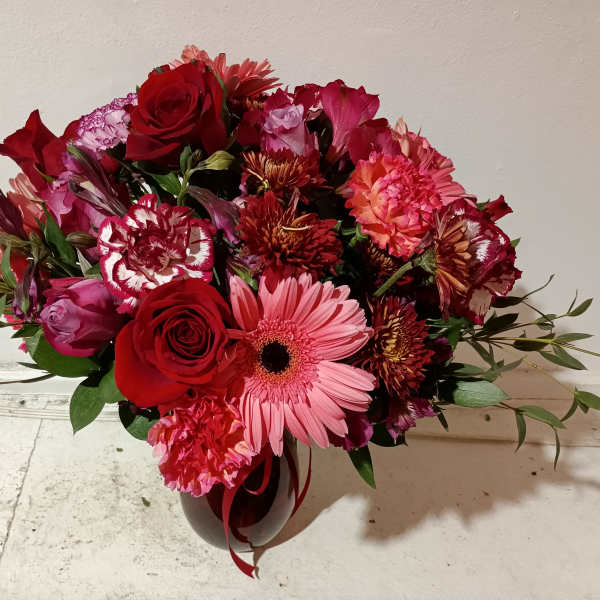 Mixed bouquet of red and pink flowers in a vase
