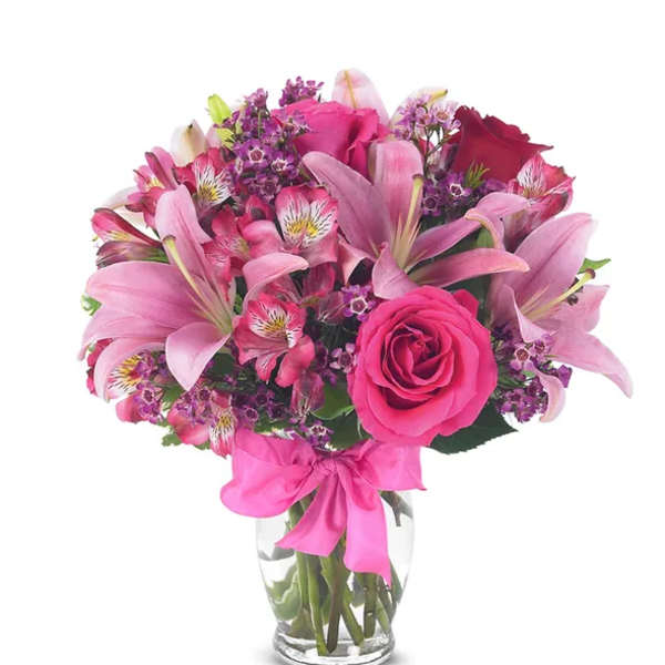 Pink bouquet with roses and lilies in a clear glass vase