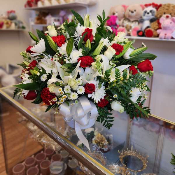 Large bouquet of red and white flowers tied with a white ribbon