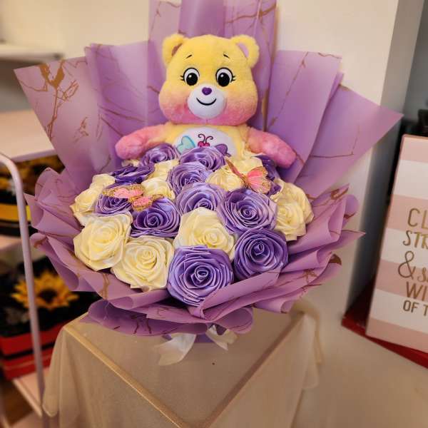 Purple and cream rose bouquet with a teddy bear topper