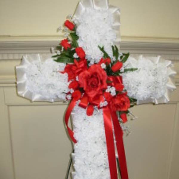 White floral cross with red roses and ribbon
