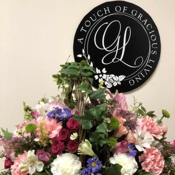 Mixed pink, white, and purple flowers in a wicker basket arrangement