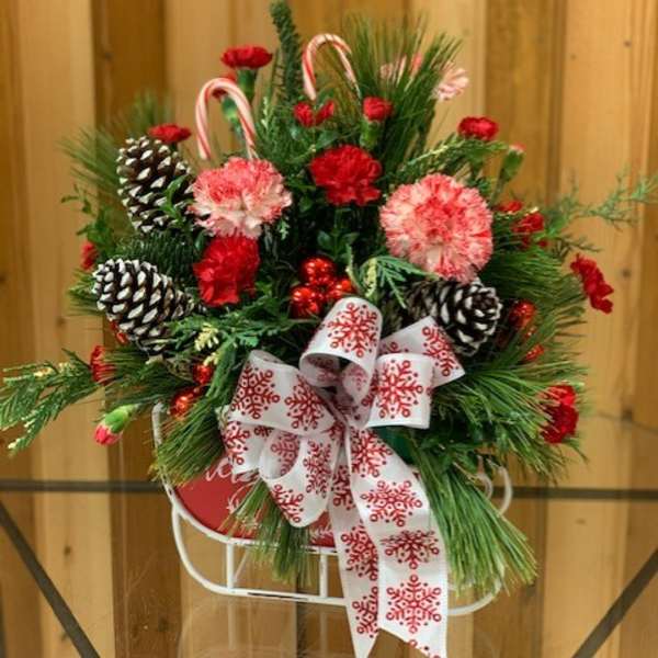 Christmas arrangement with pinecones, candy canes, and a snowflake ribbon