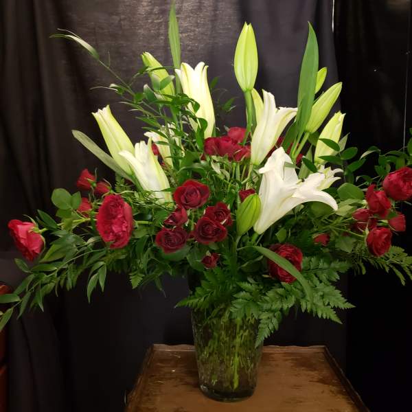 Red roses and white lilies in a clear glass vase