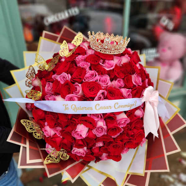 Large bouquet of red and pink roses with a crown and ribbon