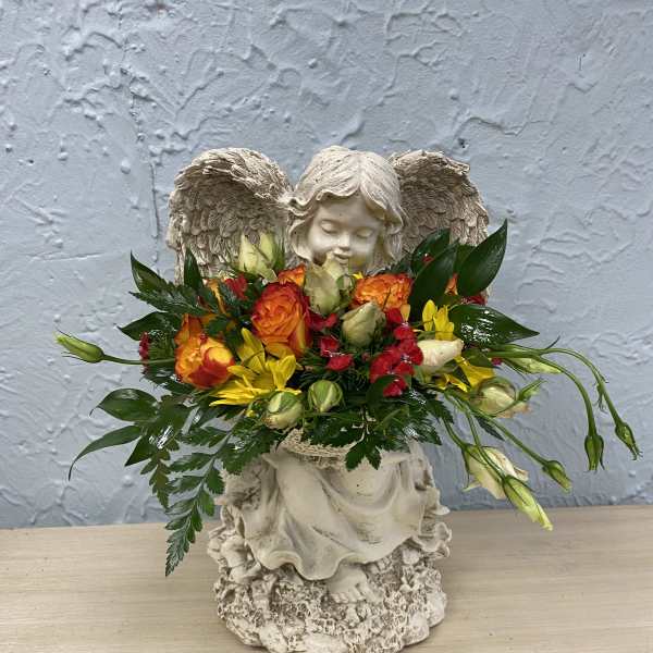 Flower arrangement in a cherub statue with orange, yellow, and red blooms