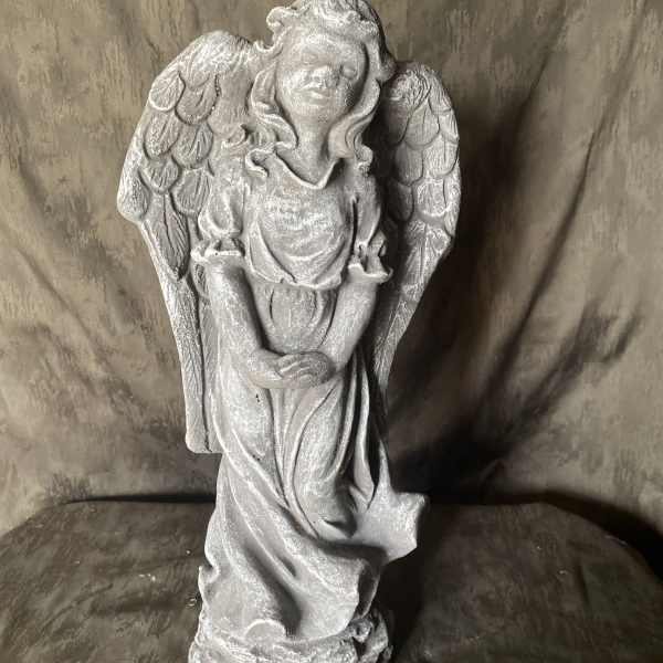Gray angel statue with folded hands and wings