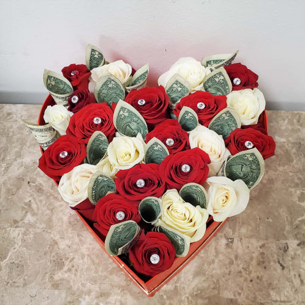 Heart-shaped box of red and white roses with folded dollar bills