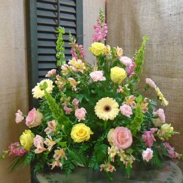 Mixed bouquet with yellow roses, pink carnations, and pale daisies