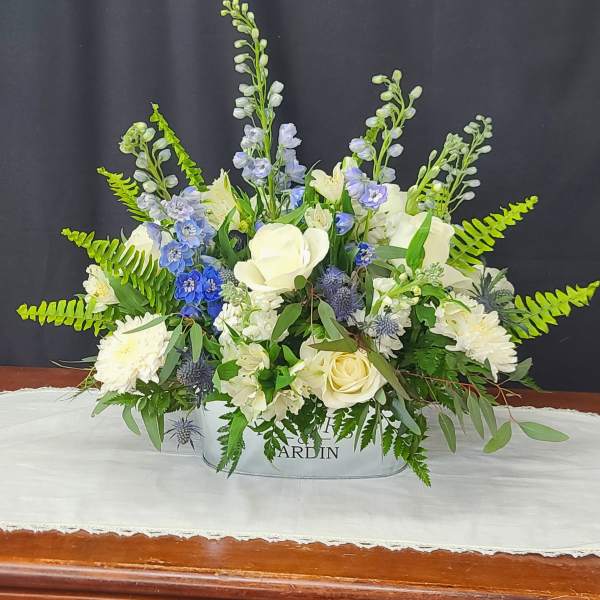 White and blue floral arrangement in a low container