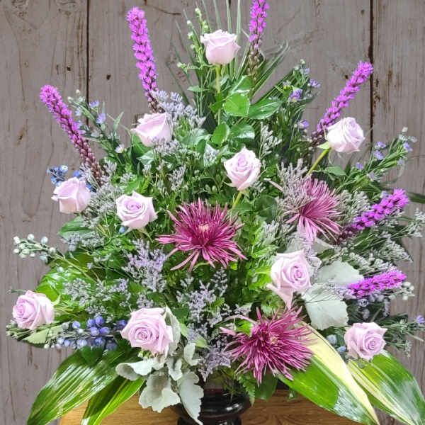 Lavender roses and purple flowers in a black vase
