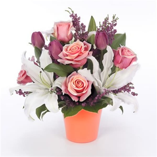 Pink roses and white lilies arranged in an orange pot