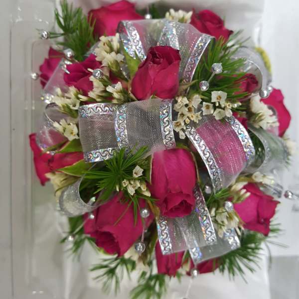 Pink rose bouquet with silver ribbon in a clear plastic box