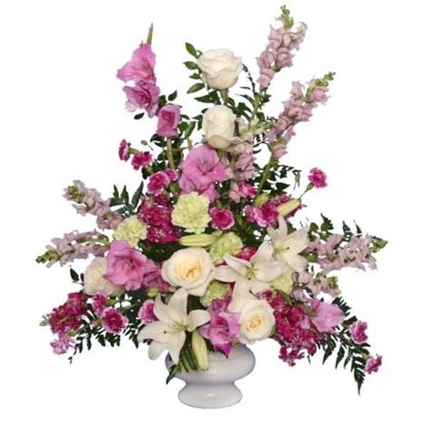 Pink and white floral arrangement in a white pedestal vase