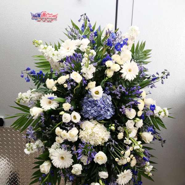 Large white and blue floral standing spray on an easel