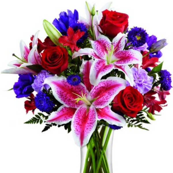 Bouquet of red roses and pink lilies in a clear glass vase
