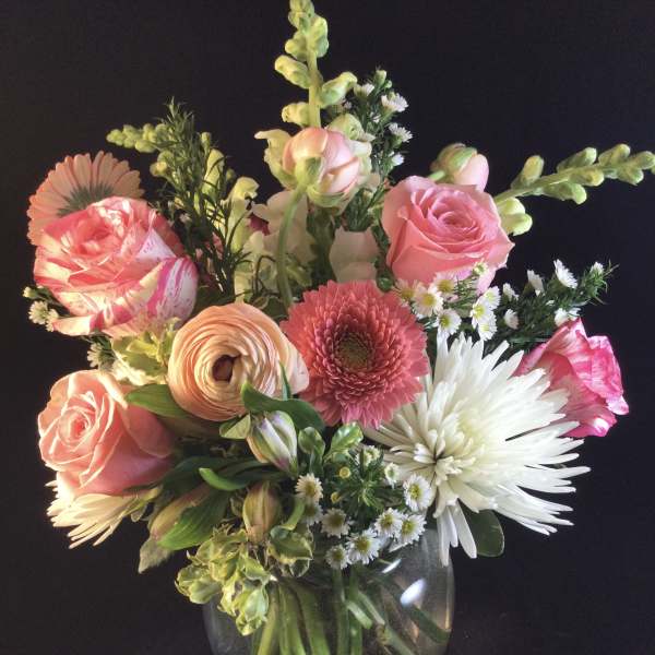 Mixed bouquet of pink and white flowers in a clear glass vase