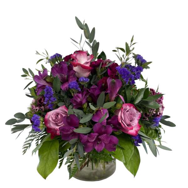 Purple and pink rose bouquet in a glass vase