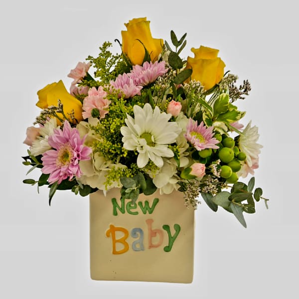 Bouquet of yellow roses and pink daisies in a vase labeled New Baby