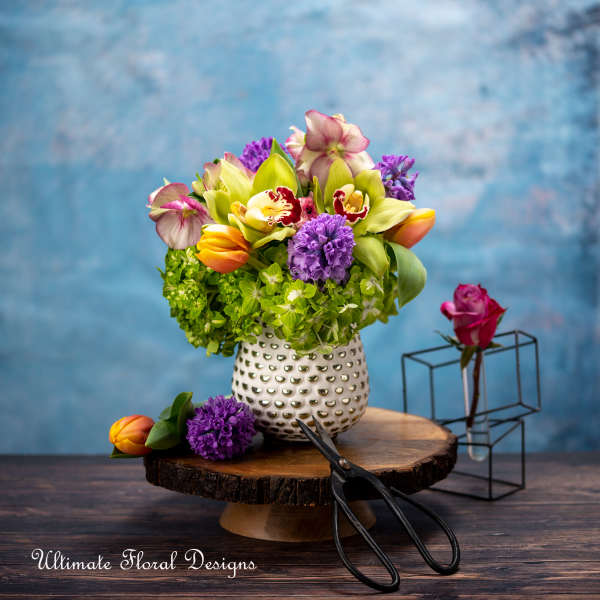 Colorful mixed flower arrangement in a white textured vase