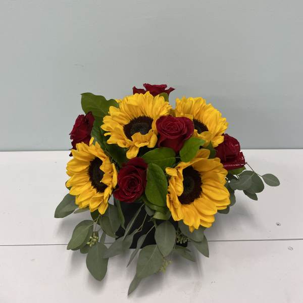 Sunflowers and red roses arranged in a low bouquet