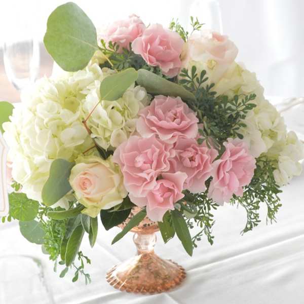Pink and white roses arranged in a glass vase