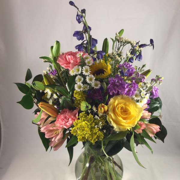 Mixed bouquet of colorful flowers in a clear glass vase