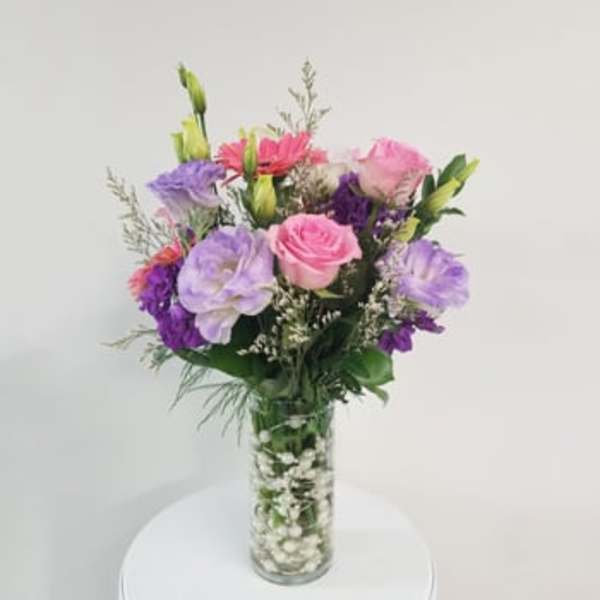 Pink, purple, and white bouquet in a clear glass vase