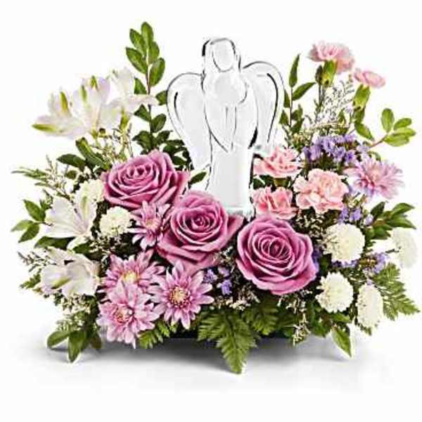 Low arrangement of pink and lavender flowers surrounding a clear angel figurine
