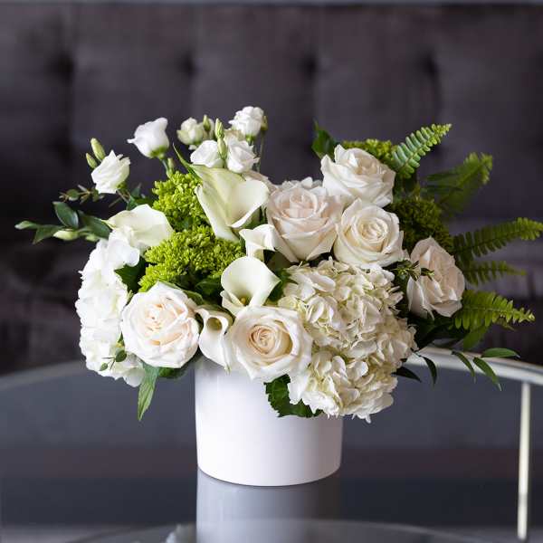 White roses and calla lilies in a white vase