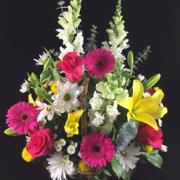 Colorful mixed flower basket with roses, gerbera daisies, lilies, and snapdragons