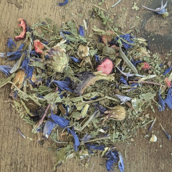 Loose dried flower petals and leaves scattered on a wooden surface