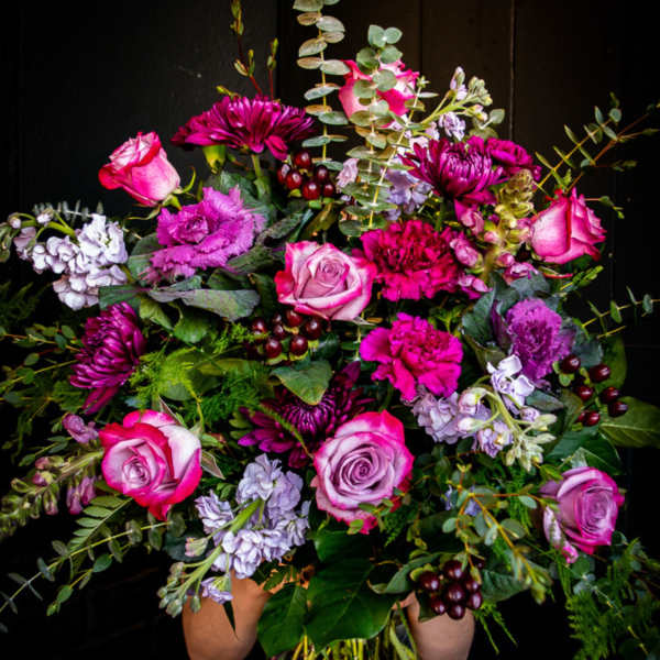 Large bouquet of pink and purple flowers in a clear glass vase
