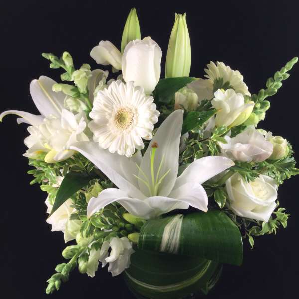 White lily and rose bouquet in a glass vase