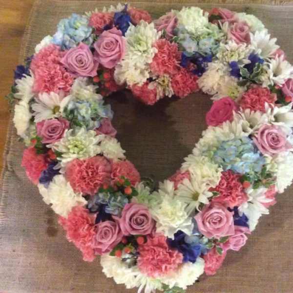 Heart-shaped floral wreath with pink, white, and blue flowers