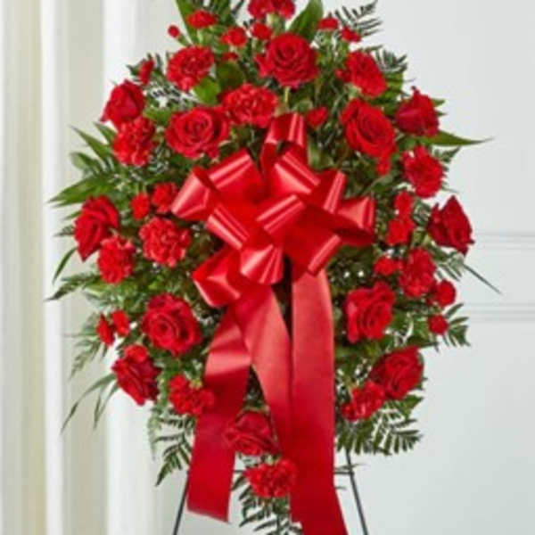 Standing spray of red roses and carnations with a large red ribbon