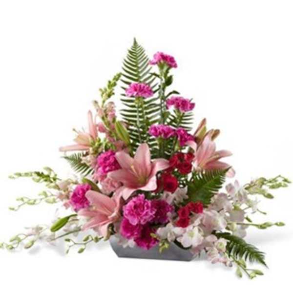 Pink lilies and carnations arranged in a low rectangular container