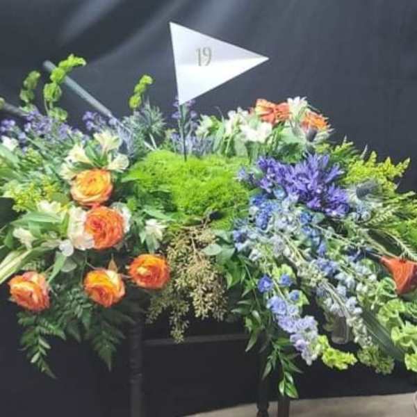 Large floral arrangement with orange roses and purple flowers