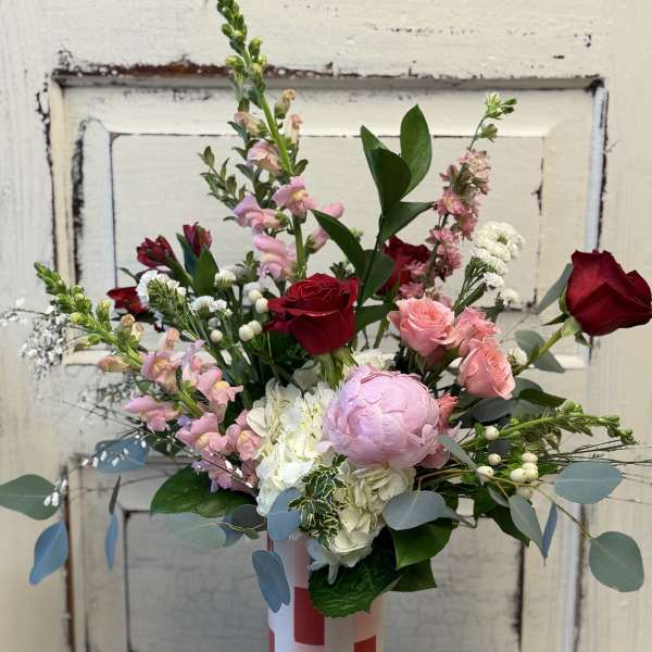 Mixed bouquet of pink and red roses in a striped vase