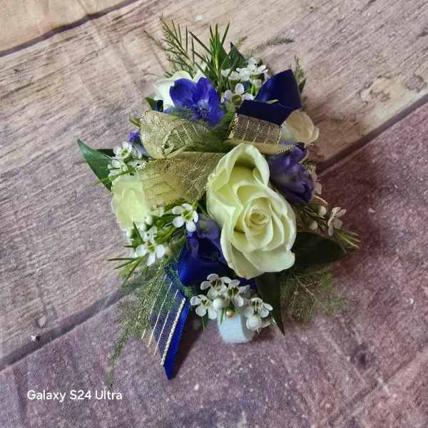 Small bouquet with white roses, blue flowers, and gold ribbon