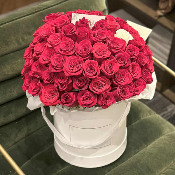 Large bouquet of red roses in a white hatbox with one white rose