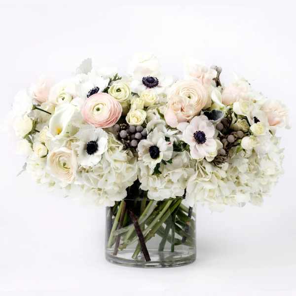 White and blush bouquet in a clear glass vase