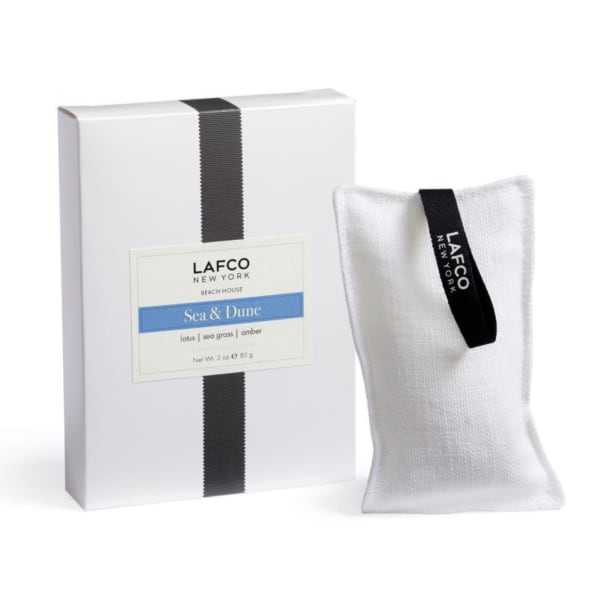 White boxed candle with a fabric sachet beside it