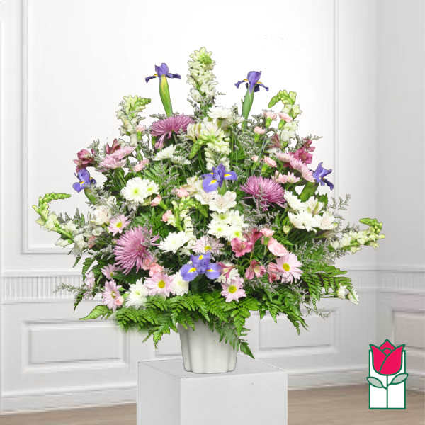 Mixed bouquet in a white vase with purple irises and pink and white daisies
