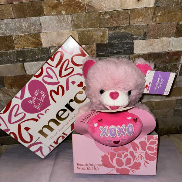 Pink teddy bear in a heart-themed gift box with a matching card
