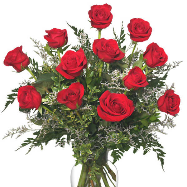 Red roses arranged in a clear glass vase with greenery